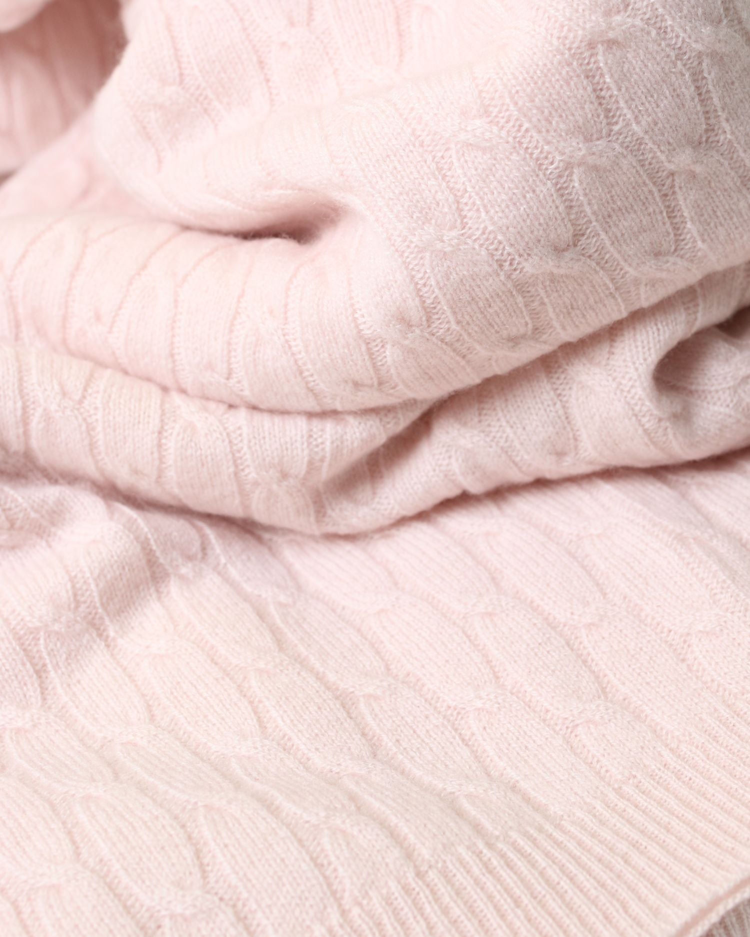 Close-up of the pattern of a cashmere blanket in pale pink.